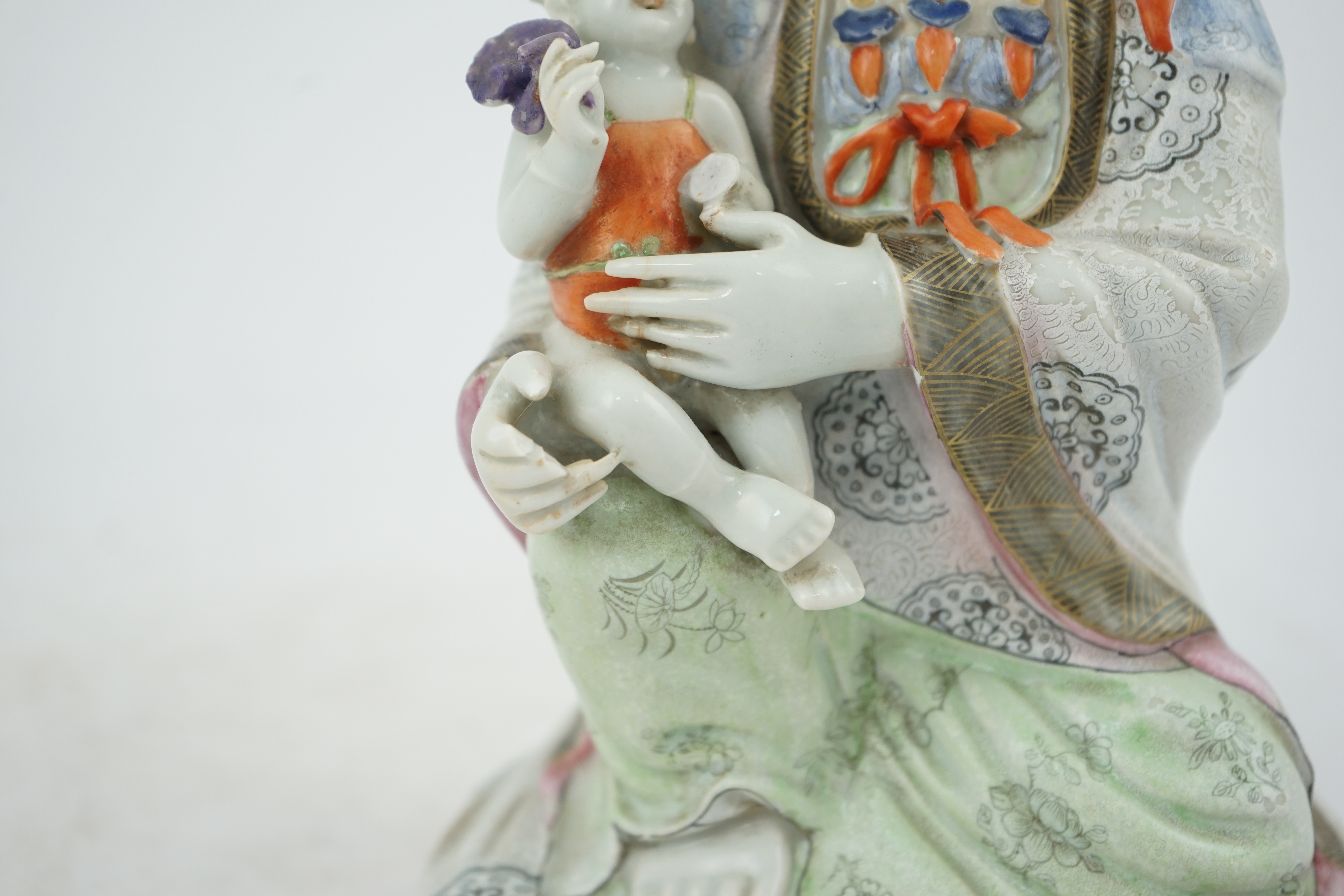 A Chinese enamelled porcelain group of Guanyin holding a child, Qianlong period